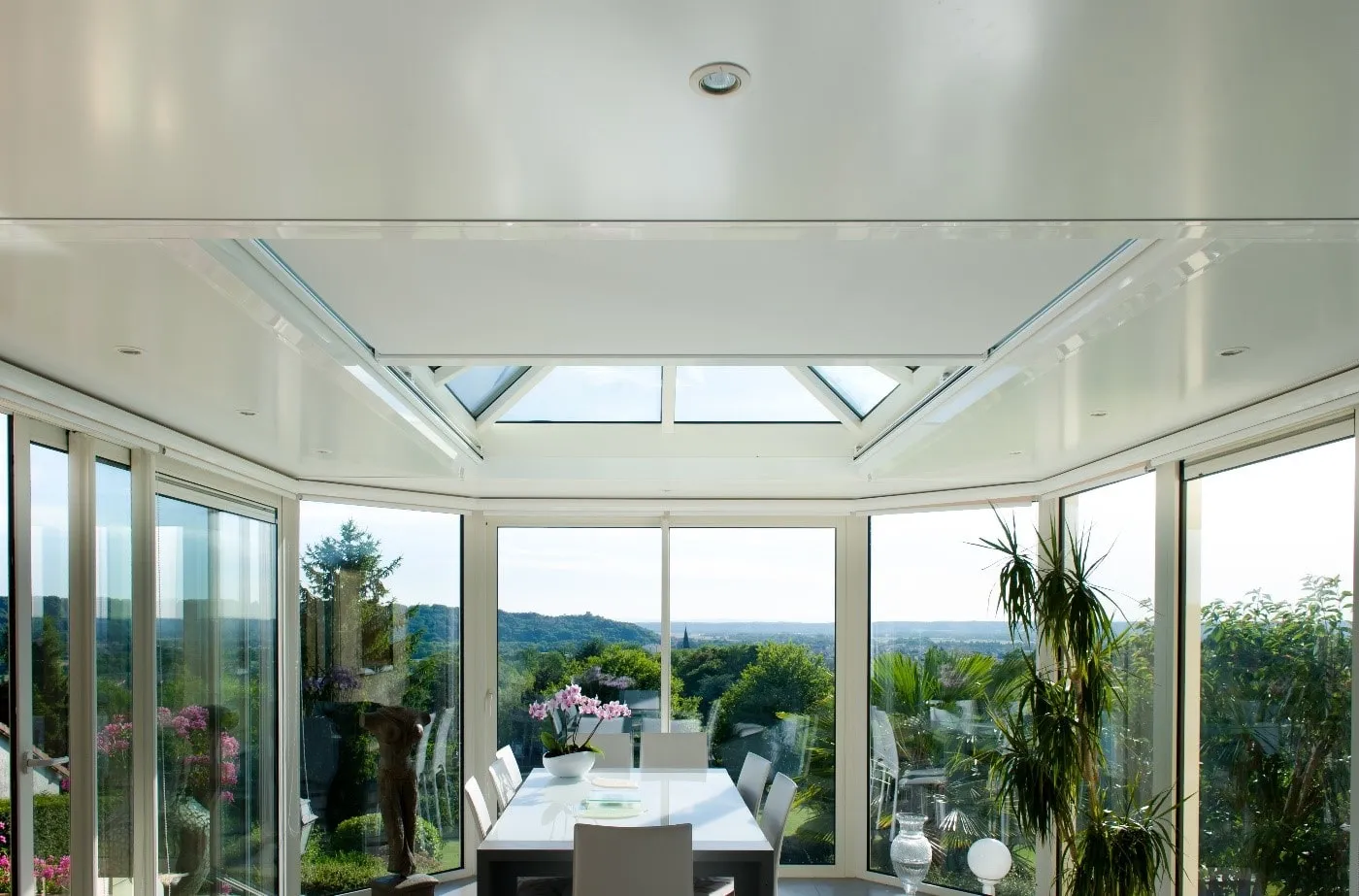 baie vitrée avec un store en partie toiture avec la vue sur le jardin
