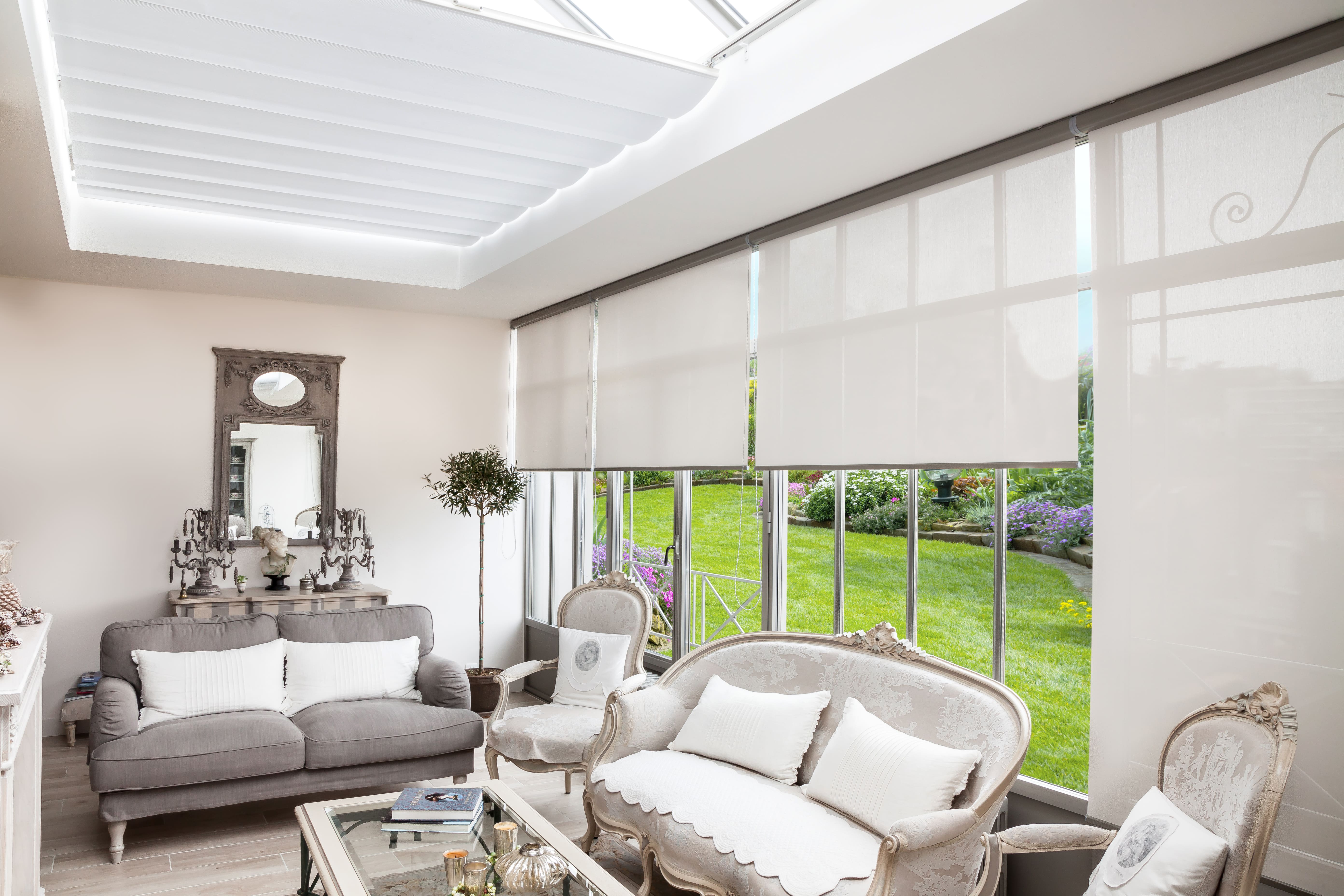 Stores anti-chaleur installés dans un salon avec une vue sur le jardin